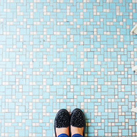 Selfie of woman's shoes on blue ceramic tile floor background.の写真素材