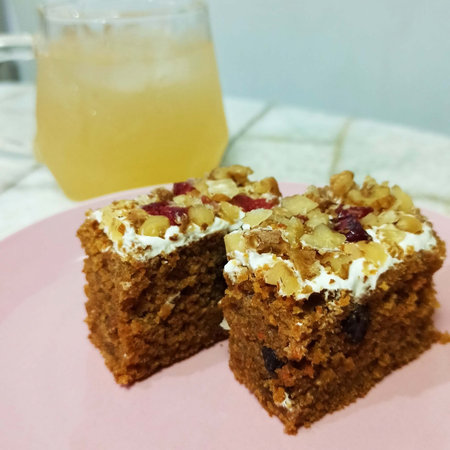 Homemade cake with nuts and raisins on a pink plateの写真素材