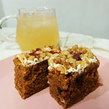 Homemade cake with nuts, raisins and honey on a pink plateの写真素材