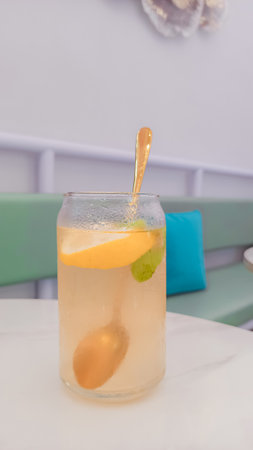 Lemonade in a glass with lemon and mint on the tableの写真素材