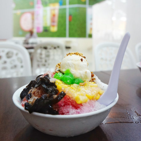 Ice-cream with sweet corn and jelly topping in white bowl.の写真素材