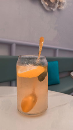 Cocktail with lemon and ice on a table in a cafeの写真素材
