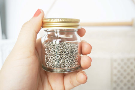 Woman holding a jar with metal chain in her hand, closeupの写真素材