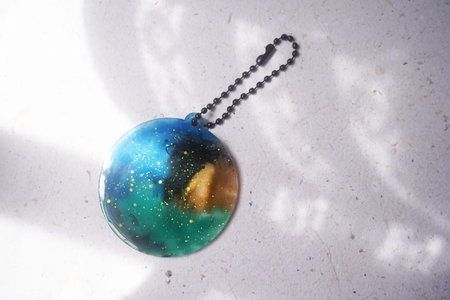 Colorful pendant painted in watercolor in the shape of a lines on a white backgroundの写真素材