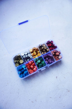 colored wax sealing bead in a box on a white background close-up