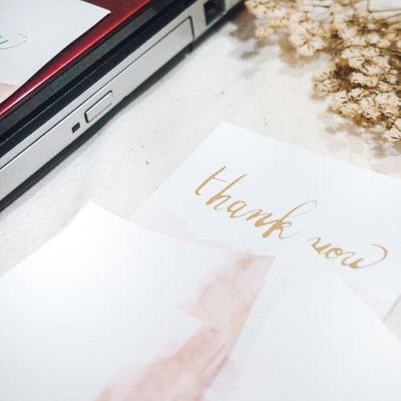 Laptop and postcard on the table with copy space for your textの写真素材
