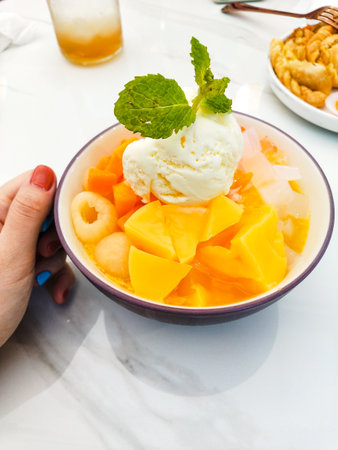 Mango ice cream in a bowl with melon and ice creamの写真素材
