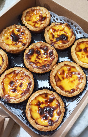 Egg tart with custard and jam in a paper box.の写真素材