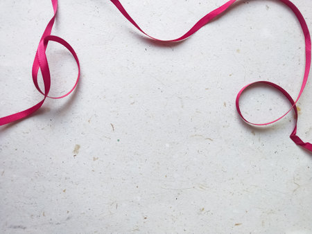 Pink ribbon on old paper background with copy space for your text.の写真素材