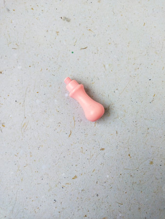 Pink plastic dog toy on a beige background. Top view.