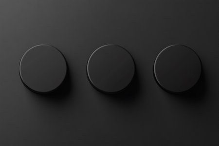3d render of black round buttons on black background. Top view.の素材