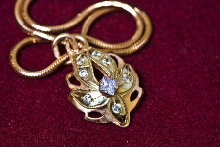 Golden pendant with chain on velvet background.の写真素材