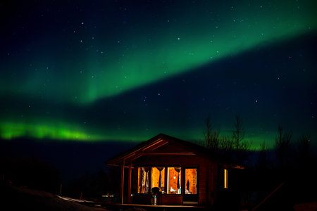 Dancing polar lighDancing polar lights with bungalow in the foreground in winter in Icelandts, bungalow the foregroundの写真素材