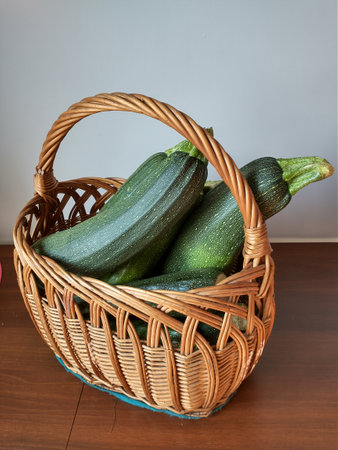 green zucchini on the table in a wicker basketの写真素材