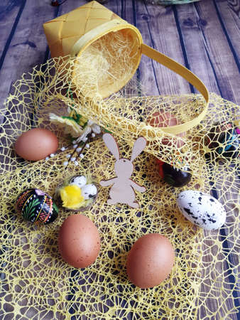 wooden table top on it a yellow Easter basket next to Christmas decorations of eggs Easter eggsの写真素材