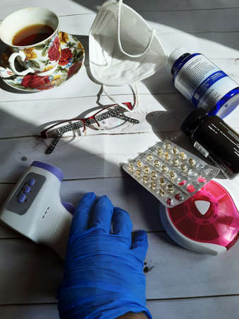 medicines, thermometer lying on the table, the image suggests illness, treatment quarantineの写真素材