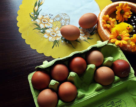 Easter decoration on a white napkin next to an egg for making Easter eggsの写真素材