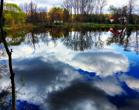 the reflection of the sky and clouds in the lake waterの写真素材