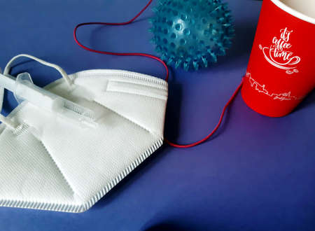 blood gift for  sufferers,on the table there is a mask next to the ball as a symbol of the virus and a red cup with a red thread as a symbol of blood donationの写真素材