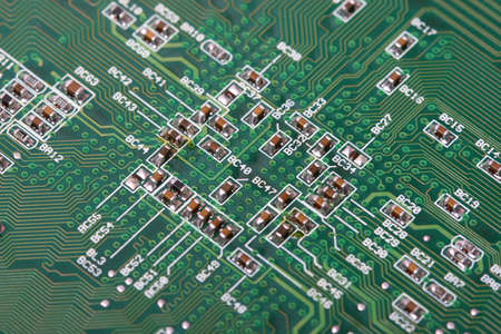 green board with electronics components, focus in center
