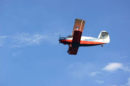 small retro biplane on blue sky