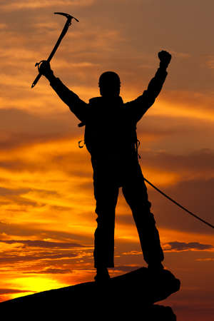 silhouette of rock climber on sunset skyの写真素材