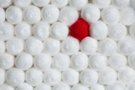 a group of usual white swabs with one unusual red