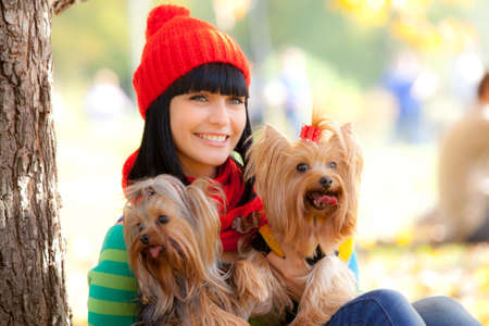 girl holds two small dog in handsの写真素材