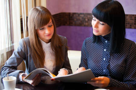 two women in cafe reading menuの写真素材
