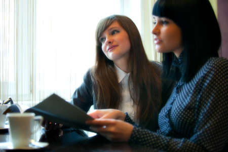 two women in cafe reading menuの写真素材