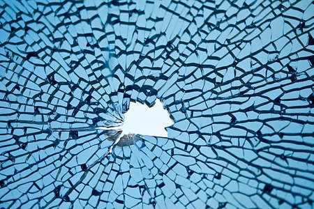 blue glass with many cracks and hole in middle