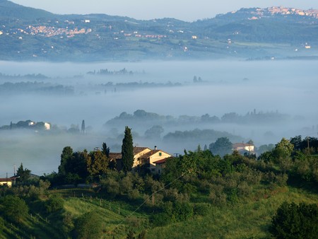 Fabulous landscape of the foggy morning in Tuscany. The valley between Montepulciano and Chiusiの写真素材