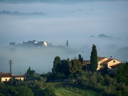 Fabulous landscape of the foggy morning in Tuscany. The valley between Montepulciano and Chiusiの写真素材