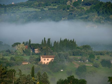 Fabulous landscape of the foggy morning in Tuscany. The valley between Montepulciano and Chiusiの写真素材