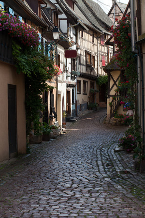 Street with half-timbered medieval houses in Eguisheim village along the famous wine route in Alsace, Franceのeditorial素材
