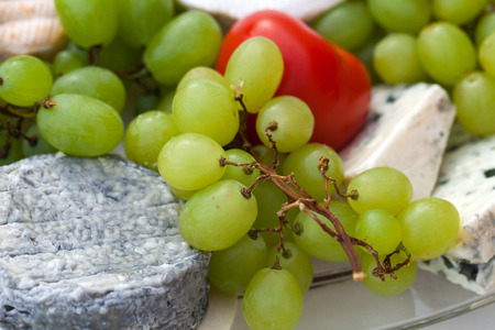 Cheese with white grapes and tomatoの写真素材