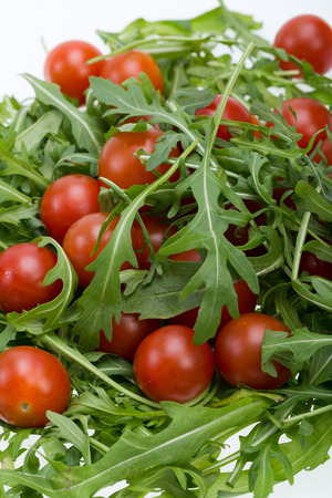 Heap of ruccola leaves and cherry tomatoesの写真素材