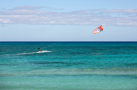 CORRALEJO, FUERTEVENTURA, SPAIN - SEPTEMBER 15, 2015:  Unknown kitesurfer surfing on a flat azure water of Atlantic ocean in Corralejo, Fuerteventura, Canary islands, Spainのeditorial素材