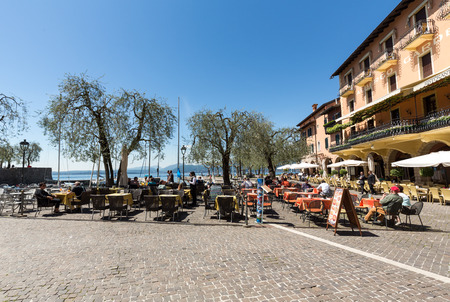 Garda lake with promenade and  restaurant in Torri del Benaco, Italyのeditorial素材