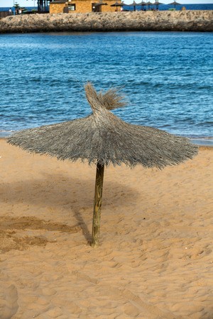 Straw umbrella on the beachの写真素材
