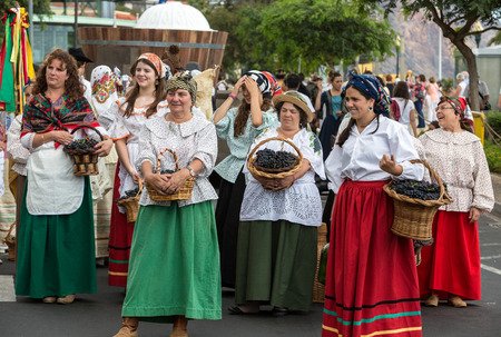 FUNCHAL, MADEIRA, PORTUGAL - SEPTEMBER 4, 2016: Group of women in traditional costume carrying a basket full of grapes durnig parade of Madeira Wine Festival in Funchal.Madeira, Portugalのeditorial素材