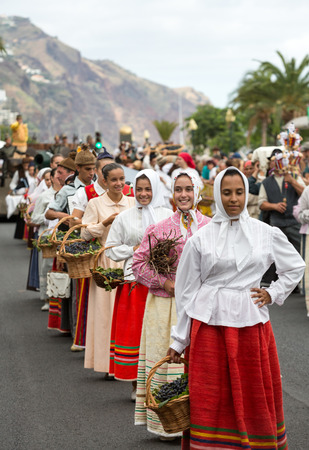 FUNCHAL, MADEIRA, PORTUGAL - SEPTEMBER 4, 2016: Group of women in traditional costume carrying a basket full of grapes durnig parade of Madeira Wine Festival in Funchal.Madeira, Portugalのeditorial素材