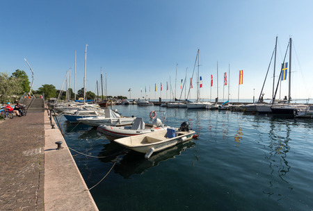 Sailboats and fishing boats at Porto di Bardolino harbor on The Garda Lake . Italyのeditorial素材