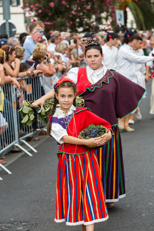 FUNCHAL, PORTUGAL - SEPTEMBER 4, 2016: Group of people in traditional costume  durnig historical and ethnographic  parade of Madeira Wine Festival in Funchal. Madeira, Portugallのeditorial素材