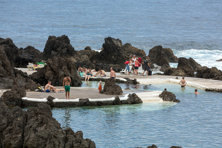 PORTO MONIZ, MADEIRA, PORTUGAL - SEPTEMBER 5, 2016: Natural rock pool of Porto Moniz. It is a public bath with water from the Atlantic Ocean.のeditorial素材