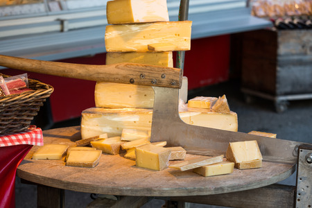 SALZBURG, AUSTRIA - APRIL 29, 2016: Cheese for sale and an old cutter or chopper used for slicing cheeses in a market at Salzburg Austriaのeditorial素材