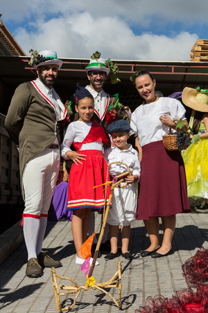 ESTREITO DE CAMARA DE LOBOS, PORTUGAL - SEPTEMBER 10, 2016:  Family wearing in traditional costumes at Madeira Wine Festival in Estreito de Camara de Lobos, Madeira, Portugal. The Madeira Wine Festival honors the grape harvest with a celebration of traditのeditorial素材