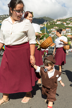 ESTREITO DE CAMARA DE LOBOS, PORTUGAL - SEPTEMBER 10, 2016: Women wearing in traditional costumes at Madeira Wine Festival in Estreito de Camara de Lobos, Madeira, Portugal. The Madeira Wine Festival honors the grape harvest with a celebration of traditioのeditorial素材