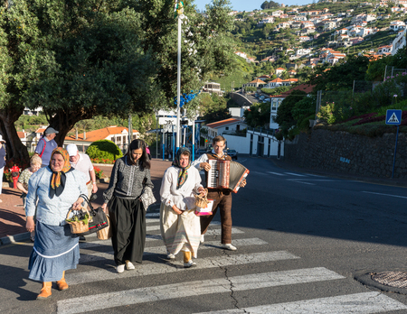 ESTREITO DE CAMARA DE LOBOS, PORTUGAL - SEPTEMBER 10, 2016:  Group of people in traditional costume  durnig historical and ethnographic  parade of Madeira Wine Festival in Estreito de Camara de Lobos on Madeira, Portugal.のeditorial素材