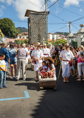 ESTREITO DE CAMARA DE LOBOS, PORTUGAL - SEPTEMBER 10, 2016: People wearing in traditional costumes at Madeira Wine Festival in Estreito de Camara de Lobos, Madeira, Portugal. The Madeira Wine Festival honors the grape harvest with a celebration of traditiのeditorial素材